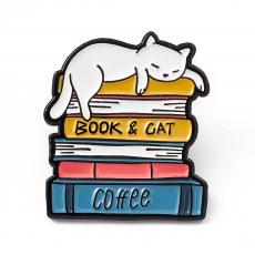 kitűző: könyveken alvó cica